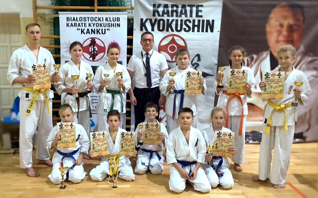 Zdjęcie zawodników karate z trenerem na zawodach